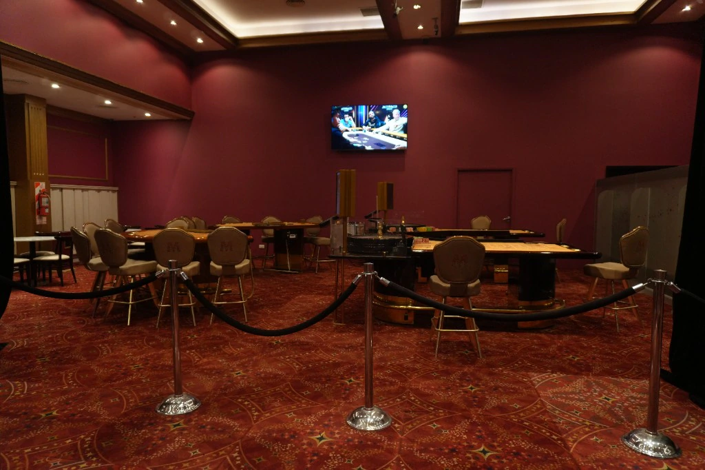 Sala de mesas en vivo de Casino Arena Maipú, con ruleta y sillas con el logo M
