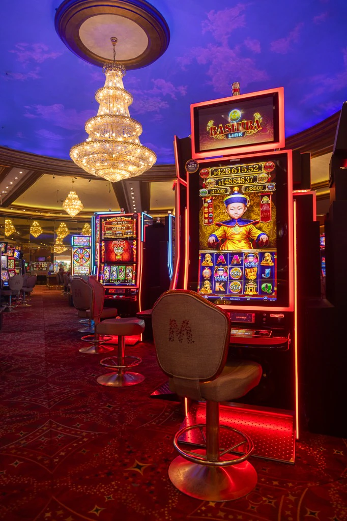 Sala de slots de Casino Arena Maipú con sillas con el logo M