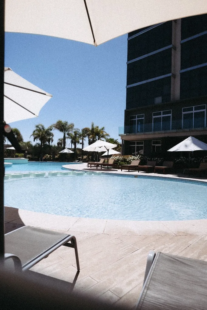 Pileta exterior del Hotel Esplendor con sombrillas y reposeras