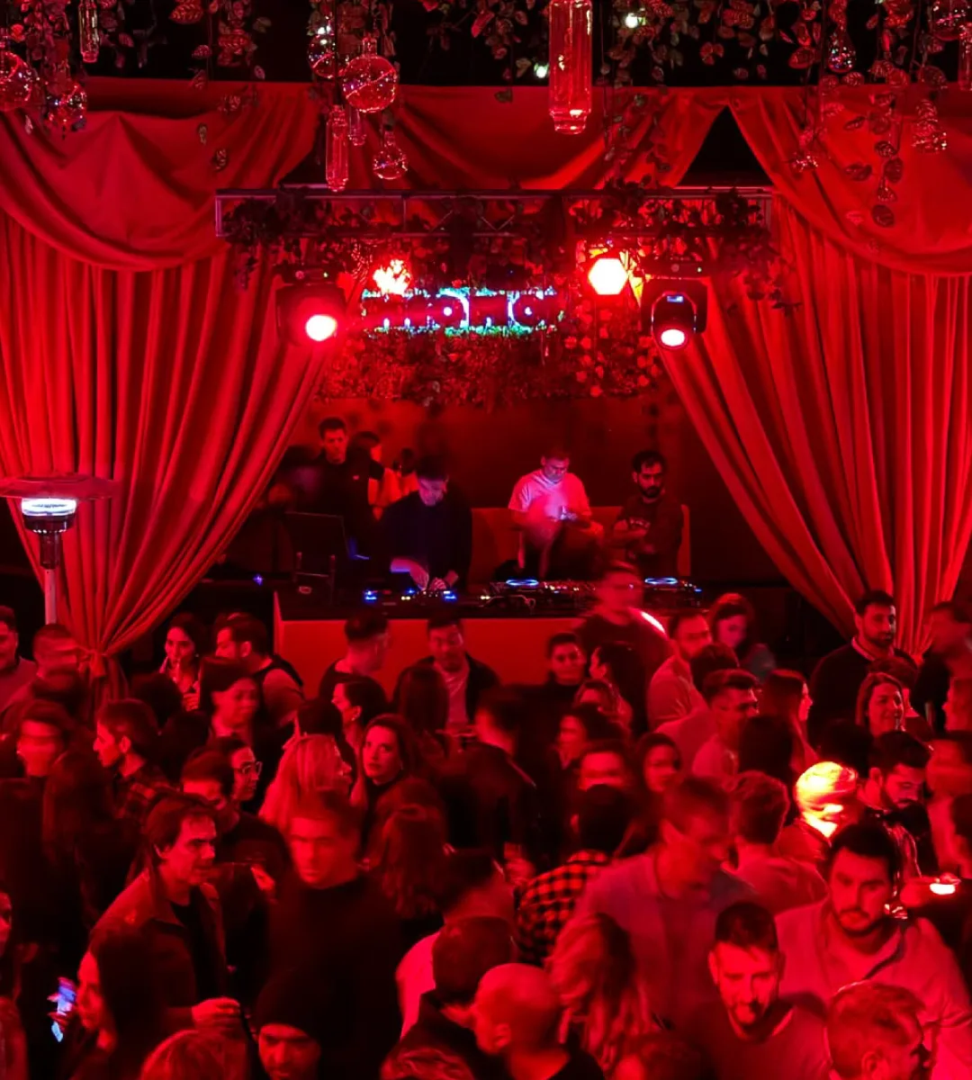 Interior de Mona Club con DJ y cortinas rojas