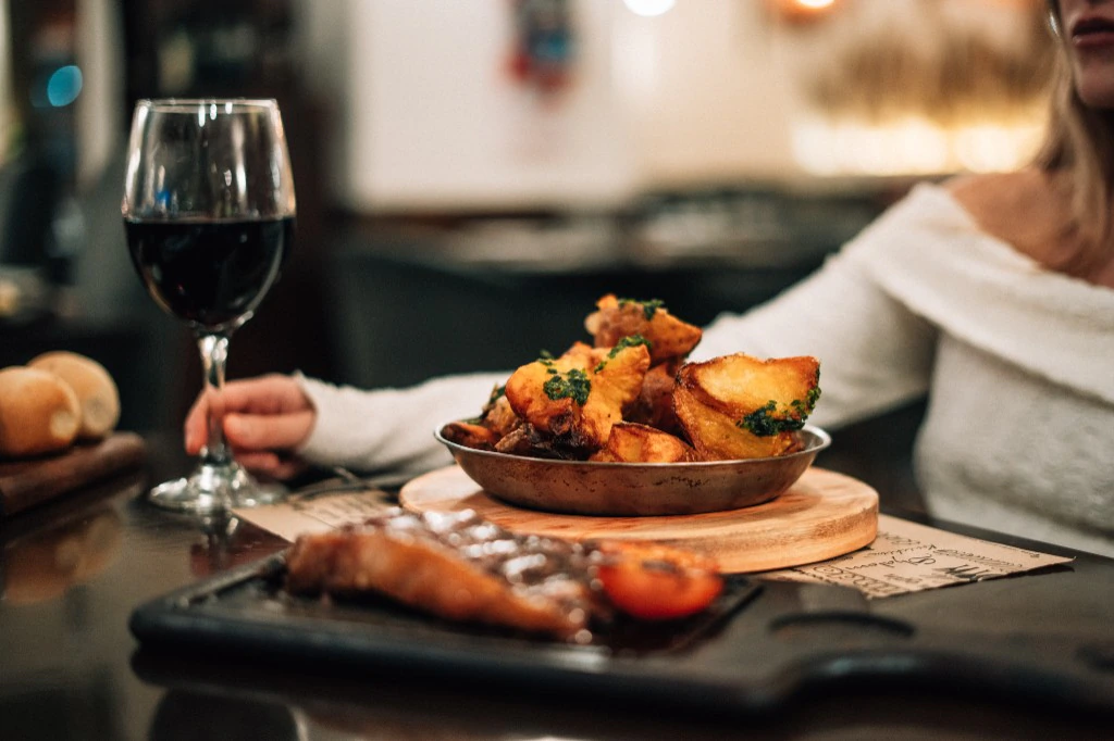 Bife, papas rústicas y vino tinto en Churrasquito