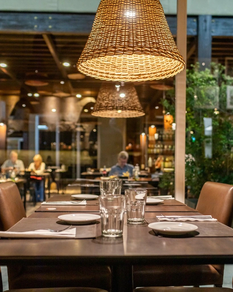 Mesa servida de Sofía Grill bajo la lámpara de mimbre